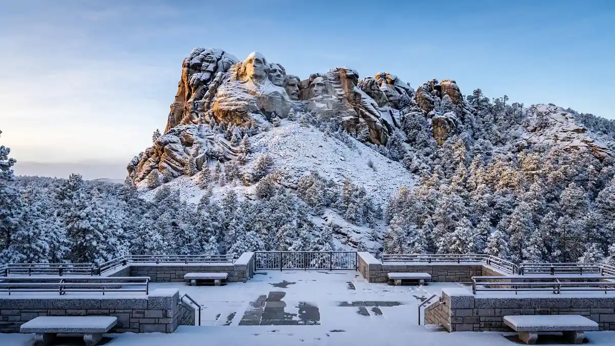 Mount Rushmore dusted with snow above winter pines in South Dakota
