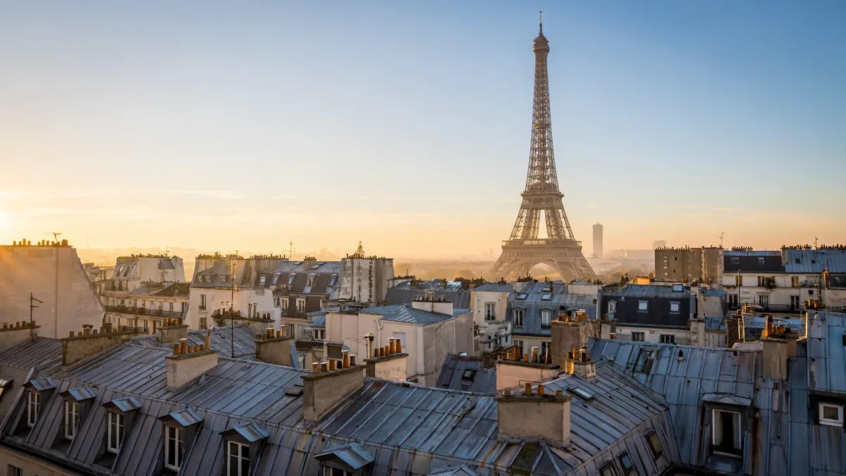 Eiffel Tower above Paris rooftops at sunrise, one of the top most visited places in the world