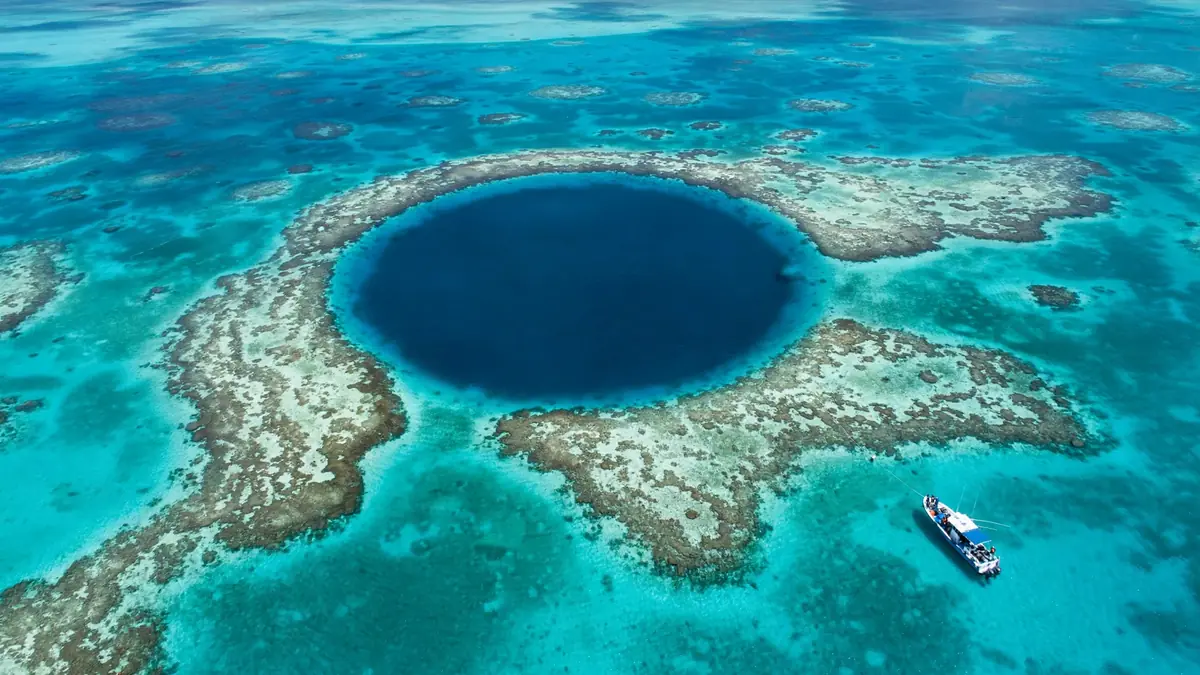 Aerial view of the Great Blue Hole surrounded by turquoise reef water, one of the top ten places to visit in Belize
