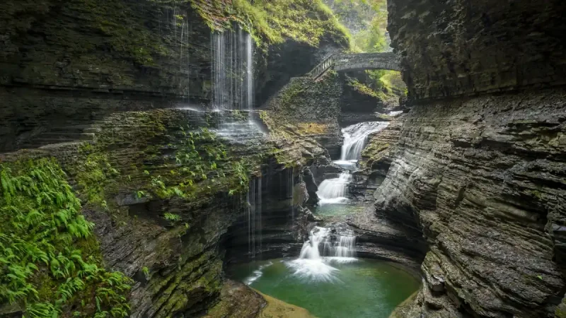 Waterfall and stone bridge inside the Watkins Glen State Park gorge trail in New York