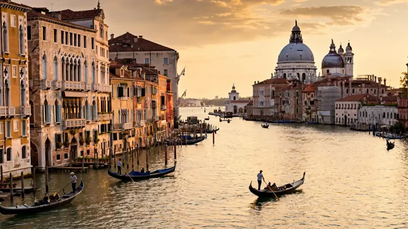 Golden-hour view of the Grand Canal with gondolas and palaces, one of the top ten places to visit in Venice Italy